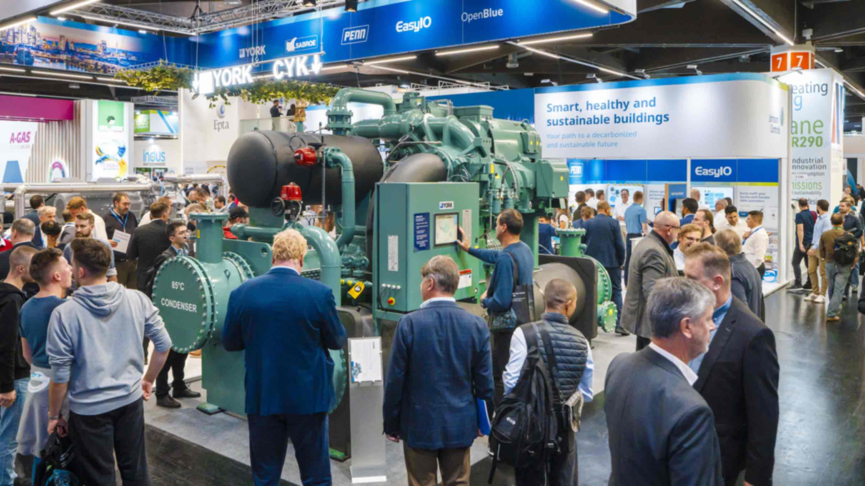 Visitors to Chillventa walk past or look at a refrigeration machine of an exhibition stand